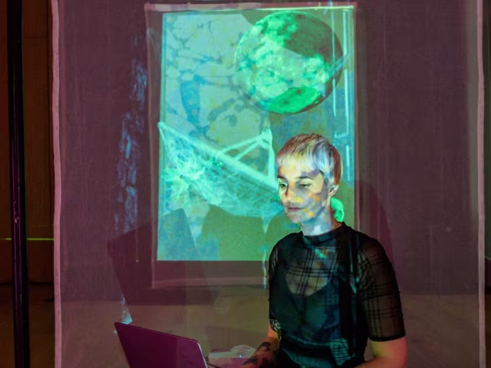 Woman on laptop with projections on face