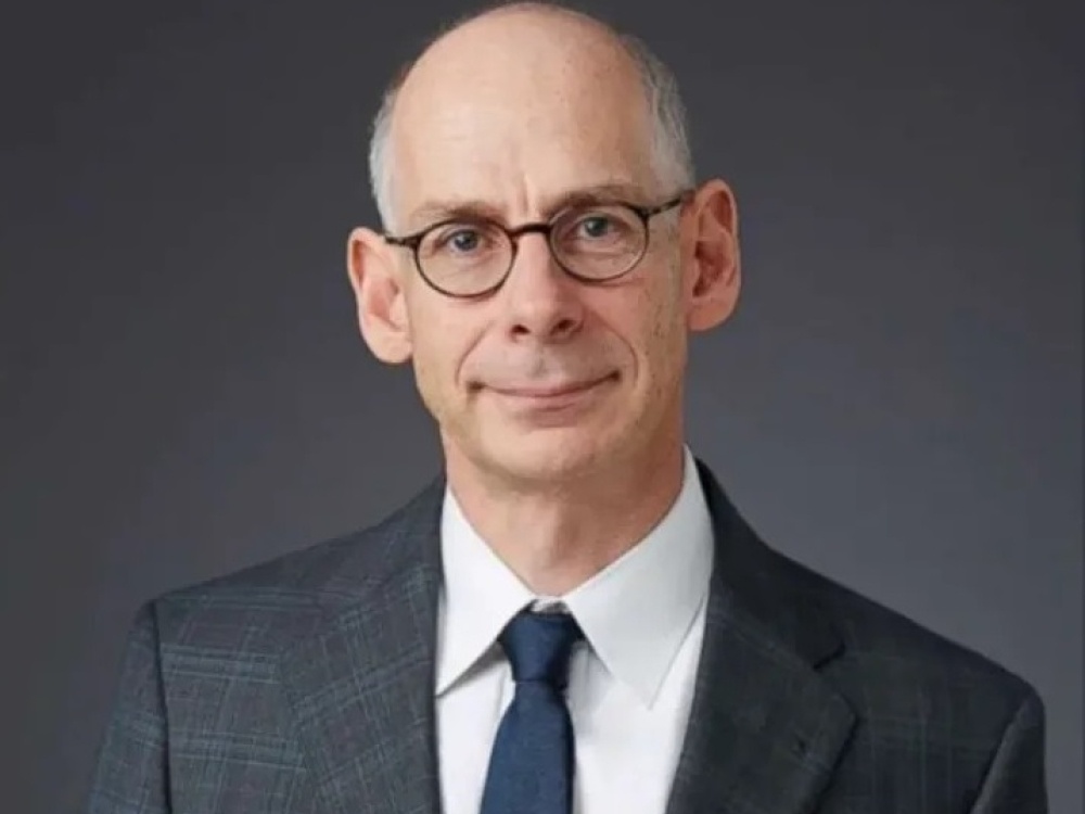 White male wearing suit and tie with glasses