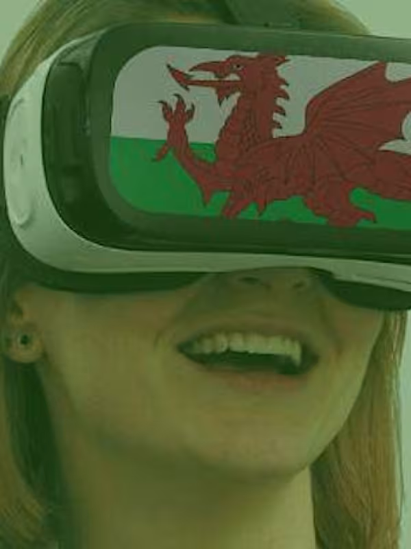 Woman wearing VR googles displaying a Welsh banner