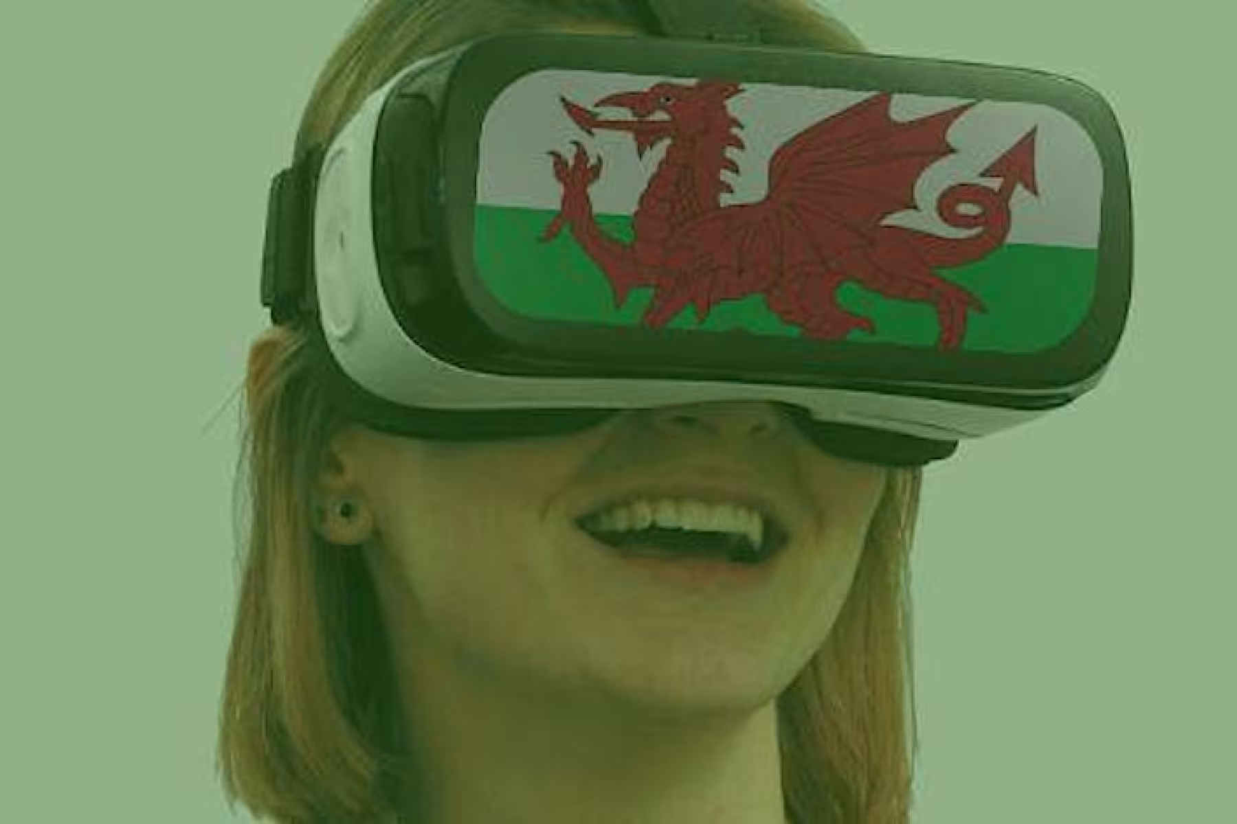 Woman wearing VR googles displaying a Welsh banner
